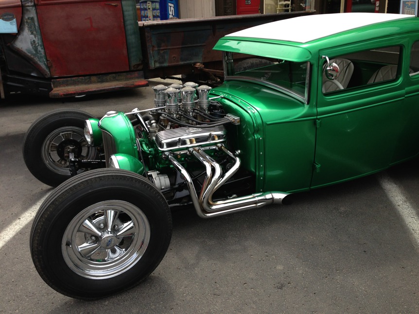 Green vintage roadster with pipes.