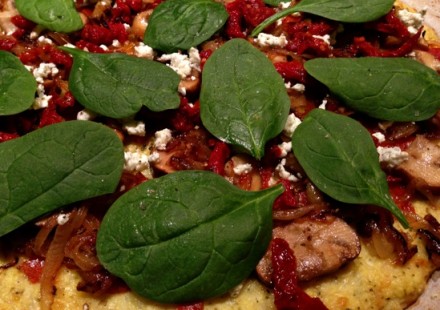 Spinach leaves, sun-dried tomatoes, and goat cheese add the perfect touches to the deep dish cauliflower skillet pizza.